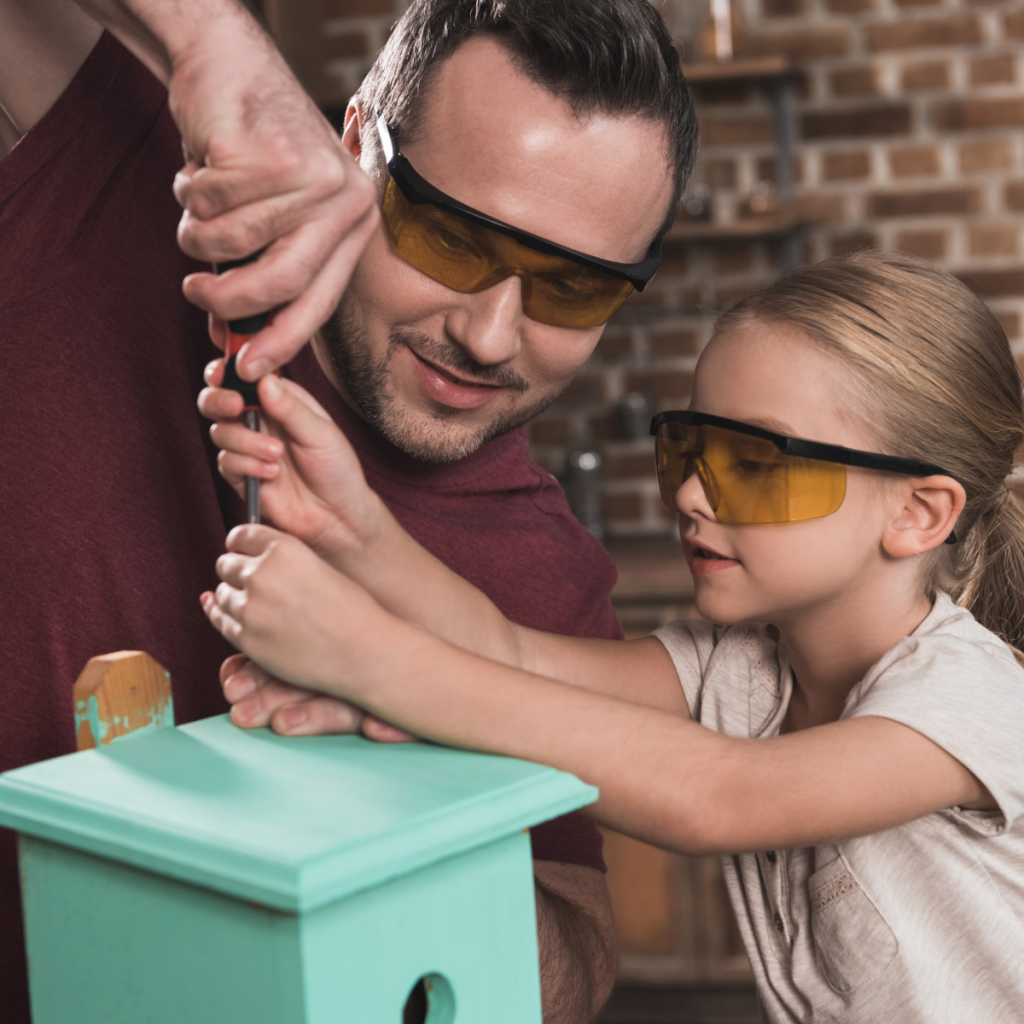 dad and daughter making a birdhouse together