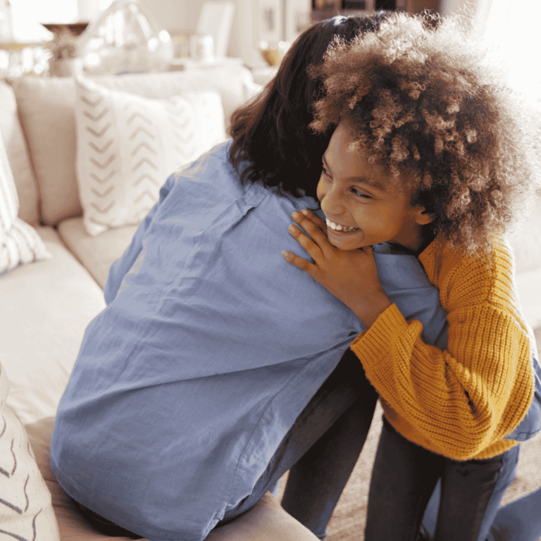 mom and daughter hugging, with daughter smiling